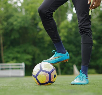 person in blue nike soccer shoes and black pants